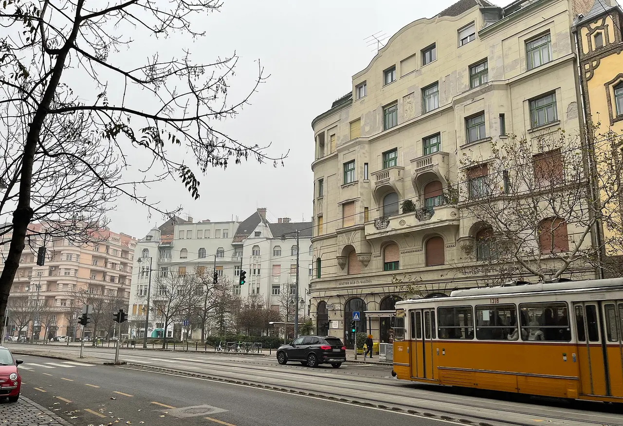 A yellow tram passing apartment buildings on Bartók Béla Boulevard