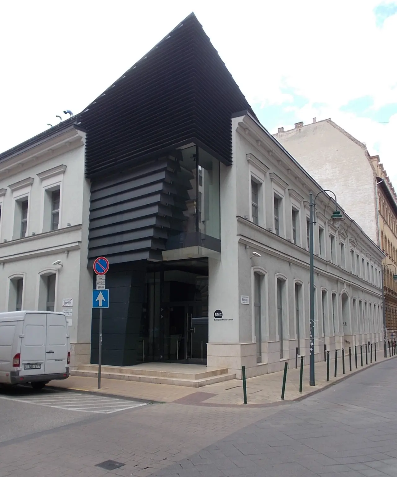 The black modern facade of the Budapest Music Center beside a neoclassical building on Mátyás utca