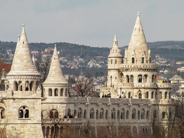 The white conical towers and terraces of Fisherman's Bastion with the Buda hills behind