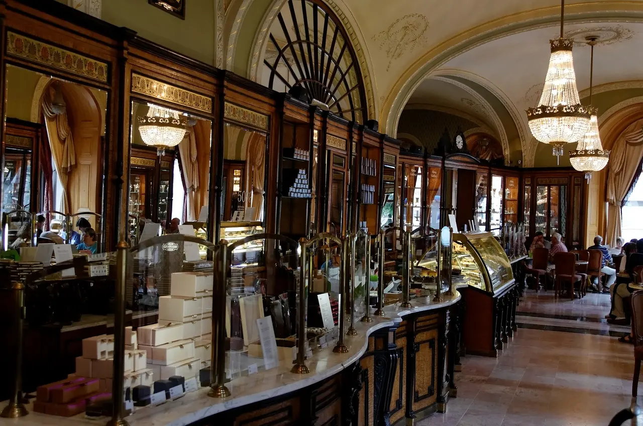 The long counter and chandeliers of the Café Gerbeaud interior