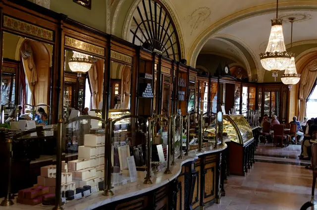 The long counter and chandeliers of the Café Gerbeaud interior
