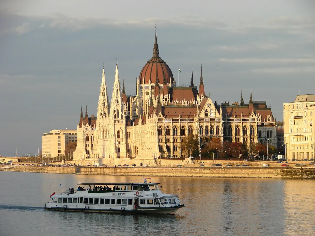 A cruise boat on the Danube in front of the Hungarian Parliament Building at sunset