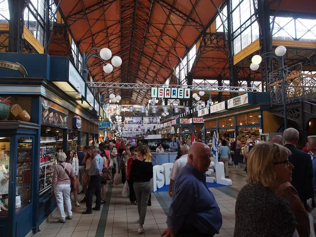Shoppers walking between stalls under the iron roof of the Great Market Hall