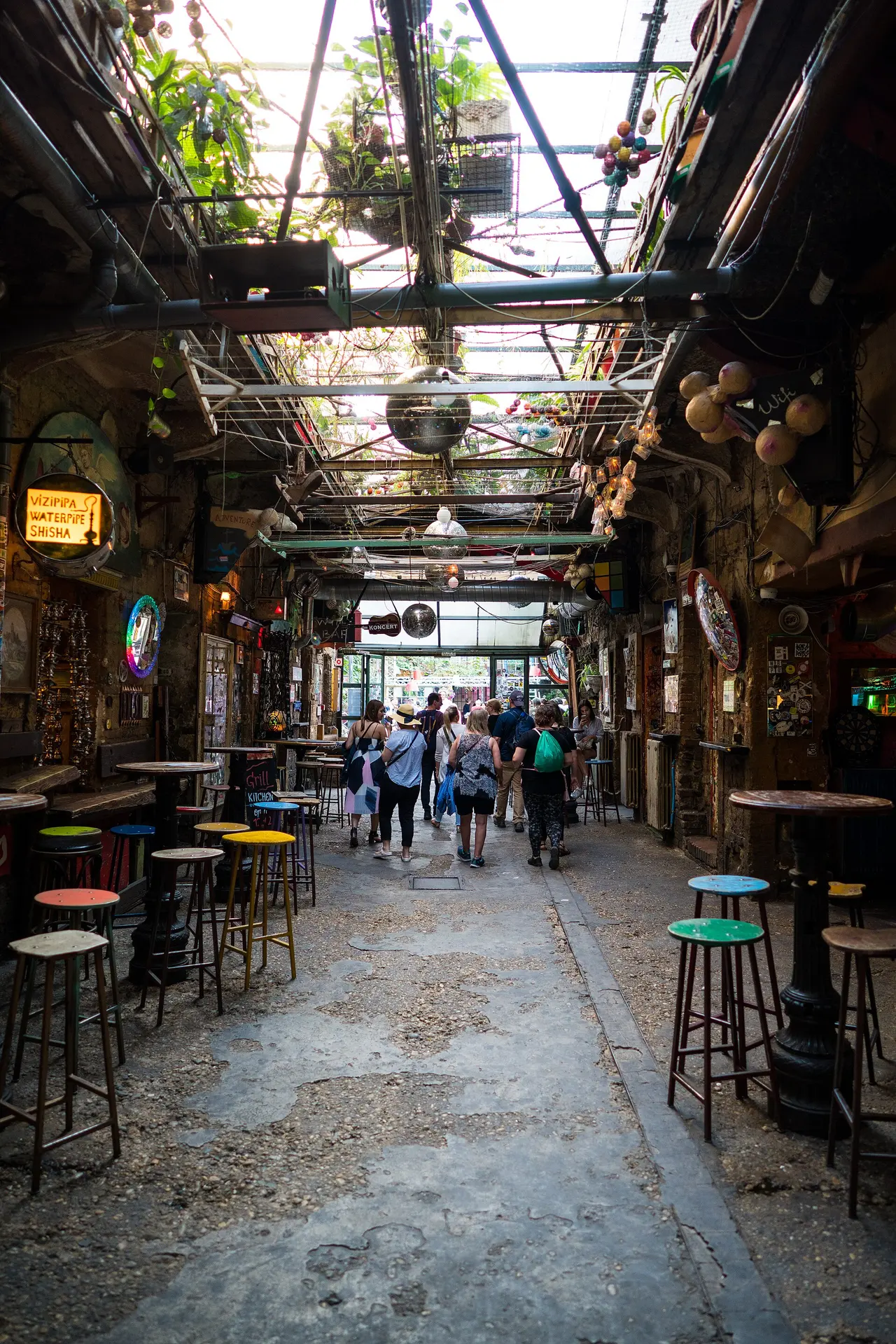 People at tables in the eclectic courtyard of the Szimpla Kert ruin bar