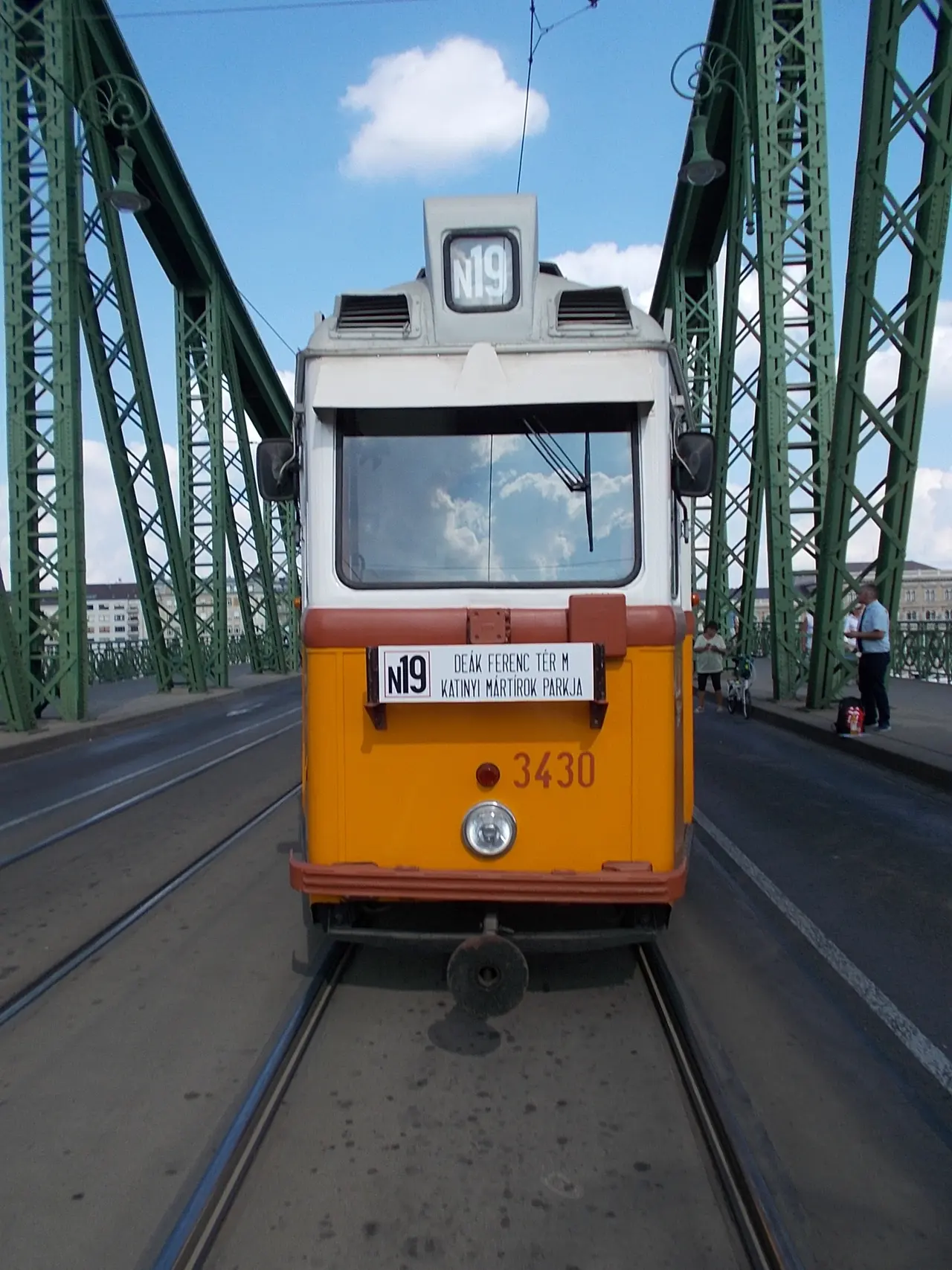 A yellow Budapest tram crossing the green iron Liberty Bridge