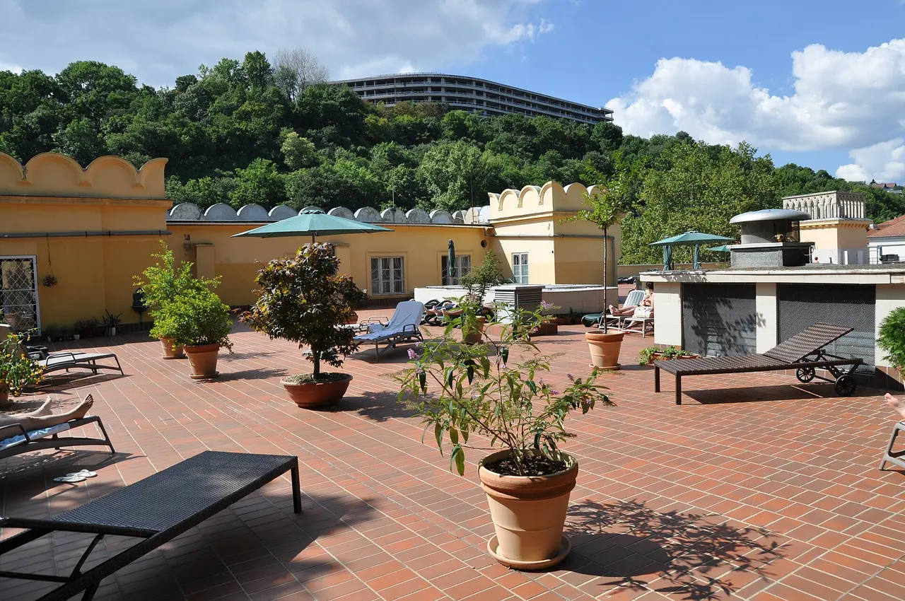 The sunbathing roof terrace of the Lukács Thermal Bath with loungers and potted plants