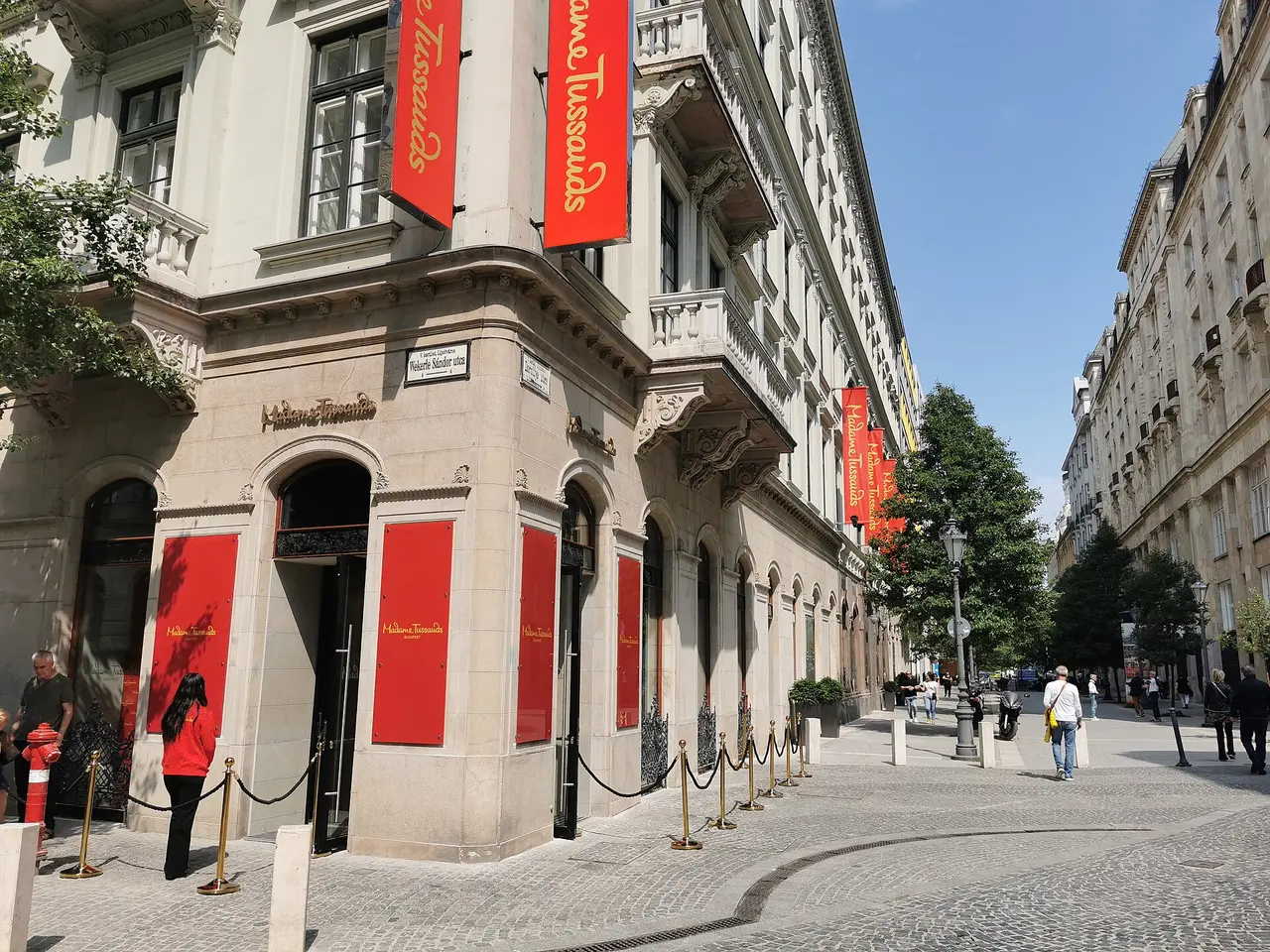 The corner entrance of Madame Tussauds Budapest, marked by red banners