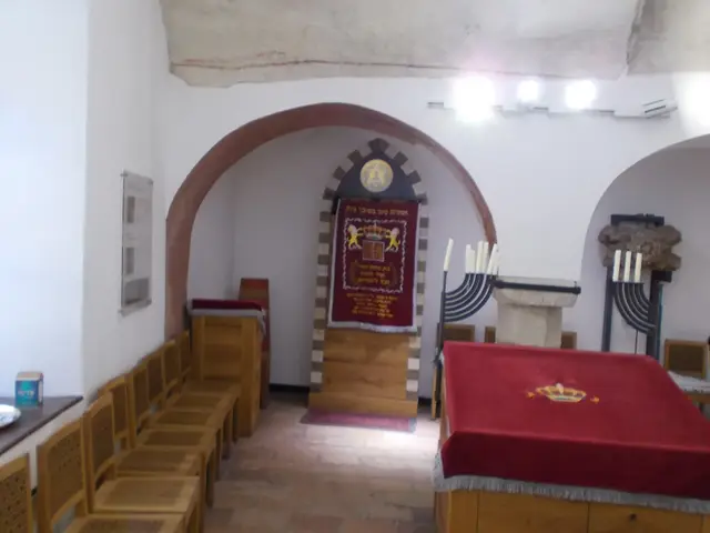 The small vaulted prayer room of the Medieval Jewish Prayer House with its Torah ark and seating