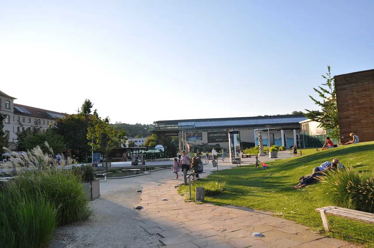 A path and lawn leading to the converted industrial halls of Millenáris Park