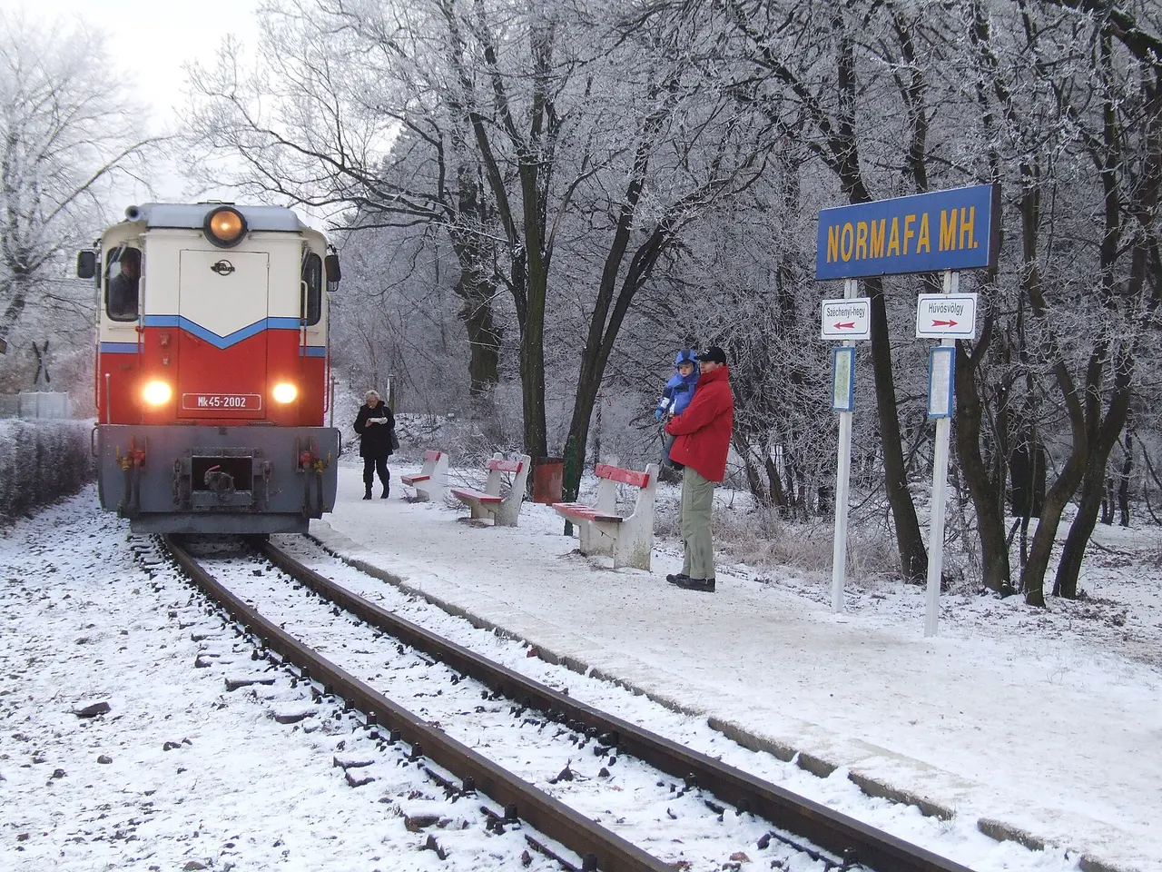 A Children's Railway train arriving at snowy Normafa station