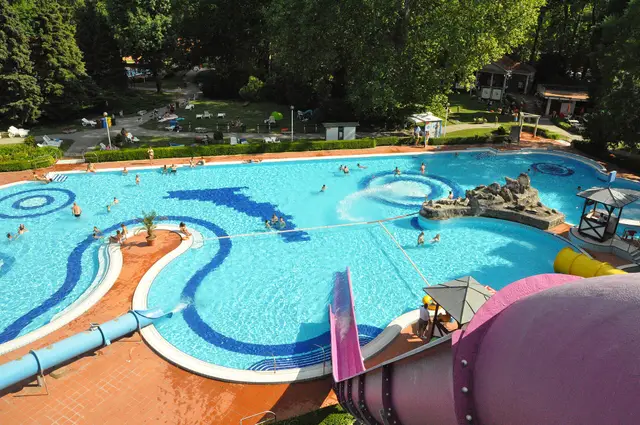Curving blue pools and water slides of the Római Open-Air Bath seen from above